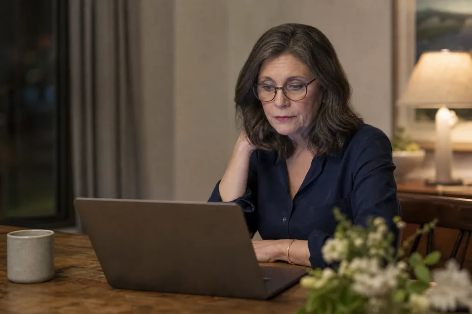 Woman reading an email from an unknown sender on a laptop